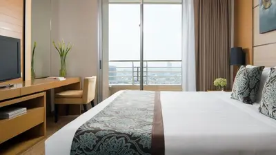 a hotel room with a bed and a desk and a television at JC Kevin Sathorn Bangkok Hotel in Bangkok