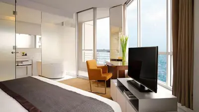 a bedroom with a bed and a television on a desk at JC Kevin Sathorn Bangkok Hotel in Bangkok