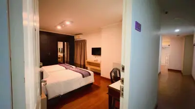 a hotel room with a bed and a television at Collection O The Step Sathorn in Bangkok
