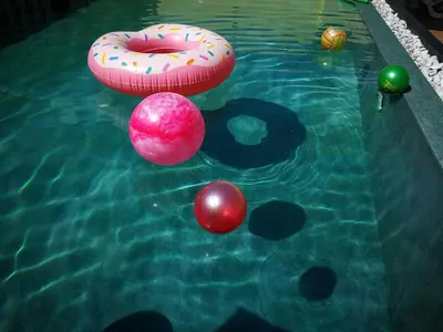 a pool with balls and a donut in the water at Barefeet Naturist Resort in Bangkok