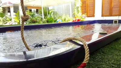 a boat with a rope next to a pool at Barefeet Naturist Resort in Bangkok