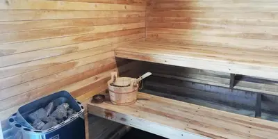 a wooden paneled sauna with a bucket in it at Barefeet Naturist Resort in Bangkok