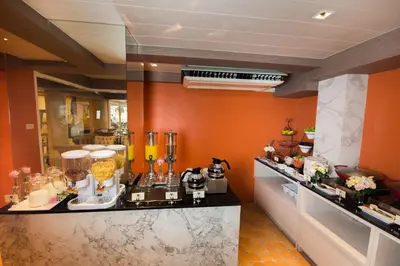 a kitchen with orange walls and a counter top with at Violet Tower at Khaosan Palace in Bangkok
