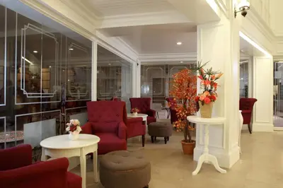 a lobby with red chairs and tables and windows at Violet Tower at Khaosan Palace in Bangkok