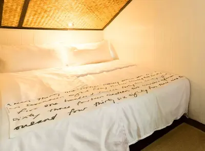 a bedroom with a bed with writing on it at Villa Mungkala in Bangkok