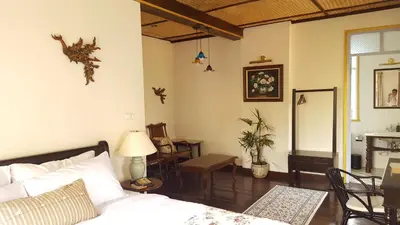 a bedroom with a bed and a table and chairs at Villa Mungkala in Bangkok