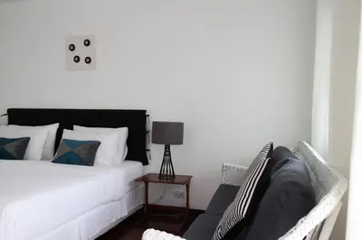 a bedroom with a bed and a chair and a lamp at Aster 9 House in Bangkok