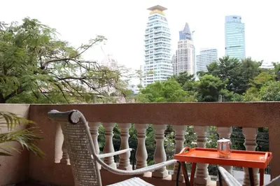 a chair and a table on a balcony at Aster 9 House in Bangkok