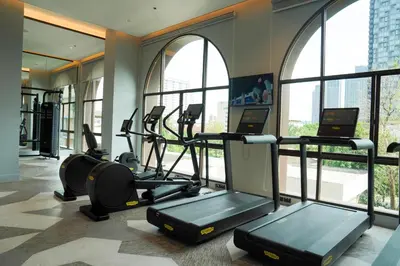 a gym with treadmills and ellipticals in a building at Marriott Executive Apartments Bangkok, Sukhumvit 101 in Bangkok