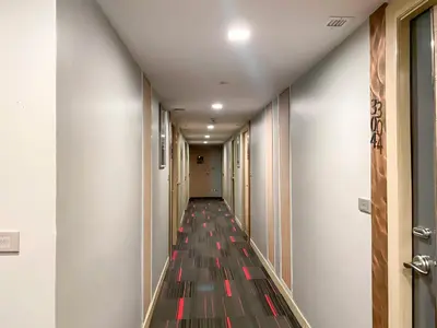 a hallway with a long corridor with red and black floors at Aspira Sukhumvit in Bangkok