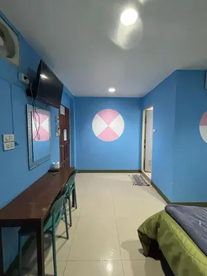 a room with blue walls and a table and chairs at Alsana Hotel in Bangkok