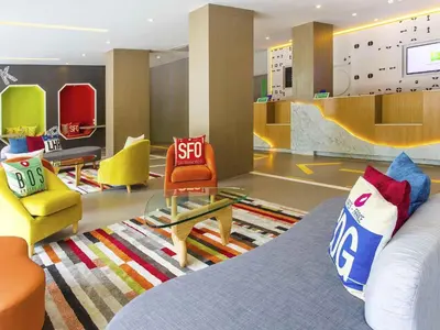 a room with a stop sign on a bed and chairs at Ibis Styles Bangkok Sukhumvit 50 in Bangkok