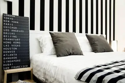 a bed with a black and white striped wall at GOODFELLAS THONG LO HOSTEL #No check in after 5pm - Check in time needed# in Bangkok