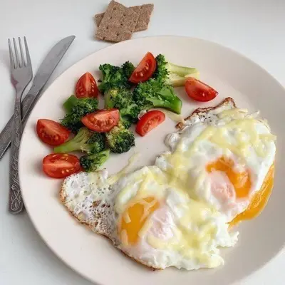 a plate of food with eggs and broccoli and tomatoes at GOODFELLAS THONG LO HOSTEL #No check in after 5pm - Check in time needed# in Bangkok