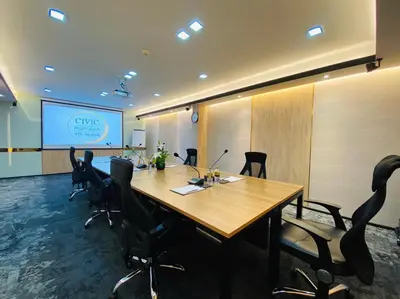 a conference room with a large wooden table and chairs at Civic Horizon Hotel & Residence in Bangkok