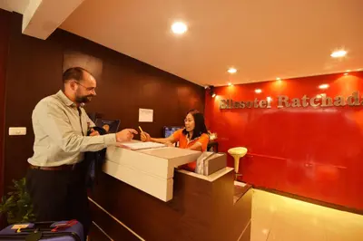 a man shaking hands with a woman at a cash register at Blissotel Ratchada in Bangkok
