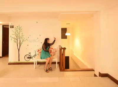 a woman in a green dress sitting on a bench at Blissotel Ratchada in Bangkok