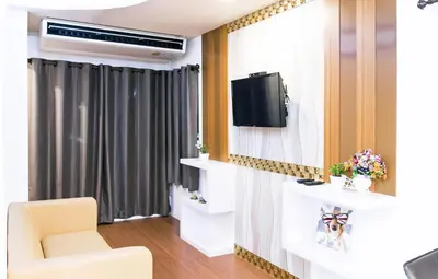 a living room with a television and a chair at Sunset Residence Pinklao in Bangkok