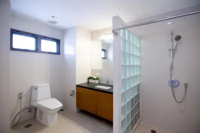 a bathroom with a toilet and a shower and a sink at Baan Sawasdee Residence in Bangkok