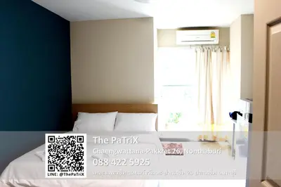 a bedroom with a bed and a window at The PaTriX Chaengwattana in Nonthaburi