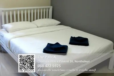 a bed with two blue towels sitting on it at The PaTriX Chaengwattana in Nonthaburi