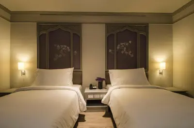 two beds in a hotel room with white sheets at imm hotel Ladprao Bangkapi Bangkok in Bangkok