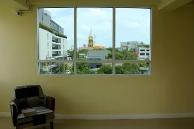 a room with a chair and a window with a view at The Arni Sukhumvit 101 in Bangkok