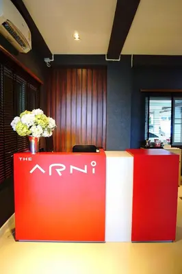 a red and white stand in an office with flowers at The Arni Sukhumvit 101 in Bangkok