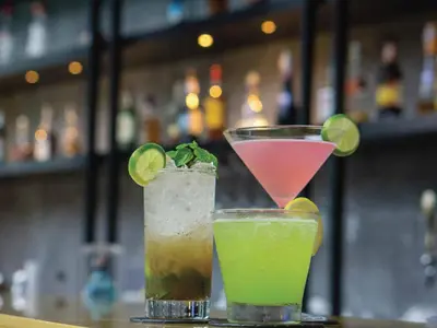 two cocktails sitting on a table in a bar at Modena by Fraser Bangkok in Bangkok