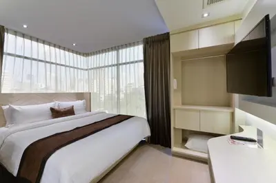 a bedroom with a bed and a large window at Aspira G Sukhumvit 33 in Bangkok