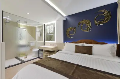 a bedroom with a large bed and a bathroom at Aspira G Sukhumvit 33 in Bangkok