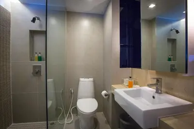 a bathroom with a toilet and a sink and a shower at Trinity Silom Hotel in Bangkok
