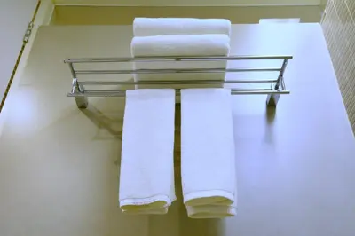 three towels on a towel rack in a bathroom at Trinity Silom Hotel in Bangkok