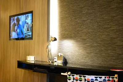 a television on a wall in a hotel room at Trinity Silom Hotel in Bangkok
