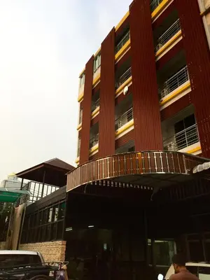 a tall red building with a car parked in front of it at Room58 in Bangkok