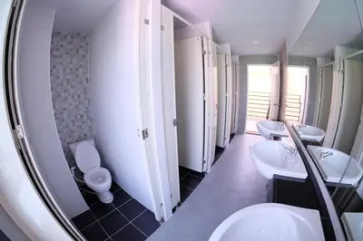 a bathroom with four sinks and toilets and a mirror at Hide Bangkok Hostel in Bangkok