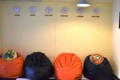 three bean bags in a room with clocks on the wall at Hide Bangkok Hostel in Bangkok