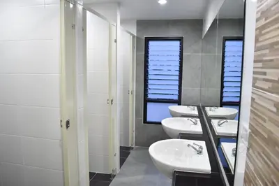 a bathroom with three sinks and two mirrors at Hide Bangkok Hostel in Bangkok