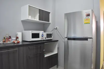 a kitchen with a refrigerator and a microwave at Hide Bangkok Hostel in Bangkok