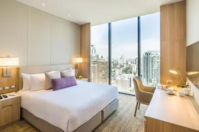 a hotel room with a bed and a large window at SKYVIEW Hotel Bangkok - Sukhumvit in Bangkok