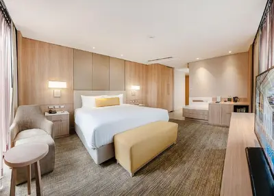 a hotel room with a large bed and a couch at SKYVIEW Hotel Bangkok - Sukhumvit in Bangkok