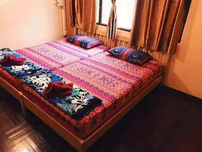 a bed with two pillows on it with a window at Pailin Guest House in Bangkok