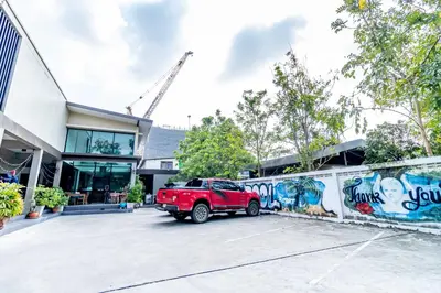 a red truck parked in a parking lot in front of a building at The Pool Resort in Bangkok