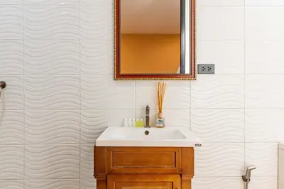 a bathroom with a sink and a mirror at The Pool Resort in Bangkok