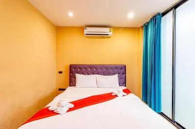 a bedroom with a bed with a window at The Pool Resort in Bangkok