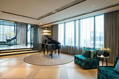 a living room with a piano and a couch at Bangkok Marriott Marquis Queens Park in Bangkok