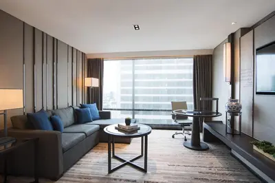 a living room with a couch and a tv at Bangkok Marriott Marquis Queens Park in Bangkok