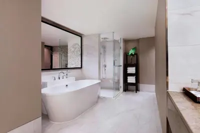 a white bathroom with a tub and a sink at Bangkok Marriott Marquis Queens Park in Bangkok