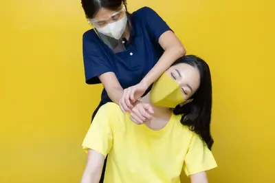 a woman is putting a yellow hat on a girl at 128 room and massage in Bangkok