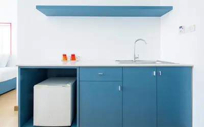 a kitchen with blue cabinets and a sink at 128 room and massage in Bangkok